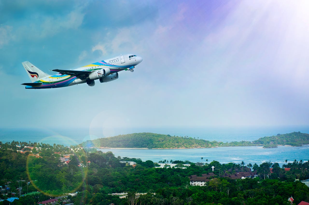 The Art of Drawing Readers In: Your attractive post title goes here Airplane soaring over Koh Samui island, Thailand, showcasing a vibrant tropical landscape in daylight.