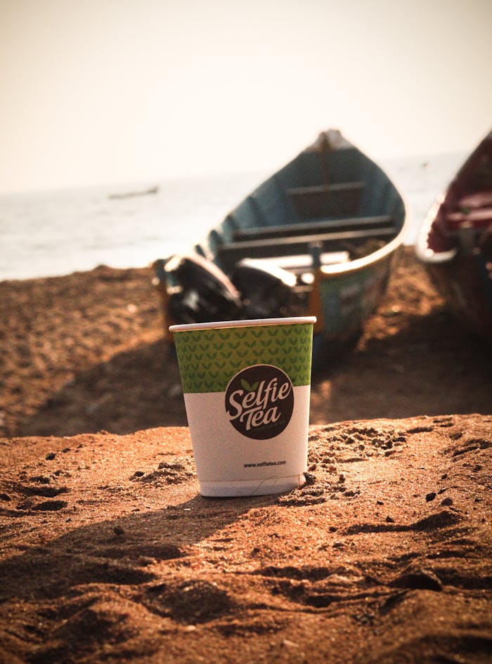 Crafting Captivating Headlines: Your awesome post title goes here A cup of tea on a sandy beach in Thiruvananthapuram, India, during sunset.